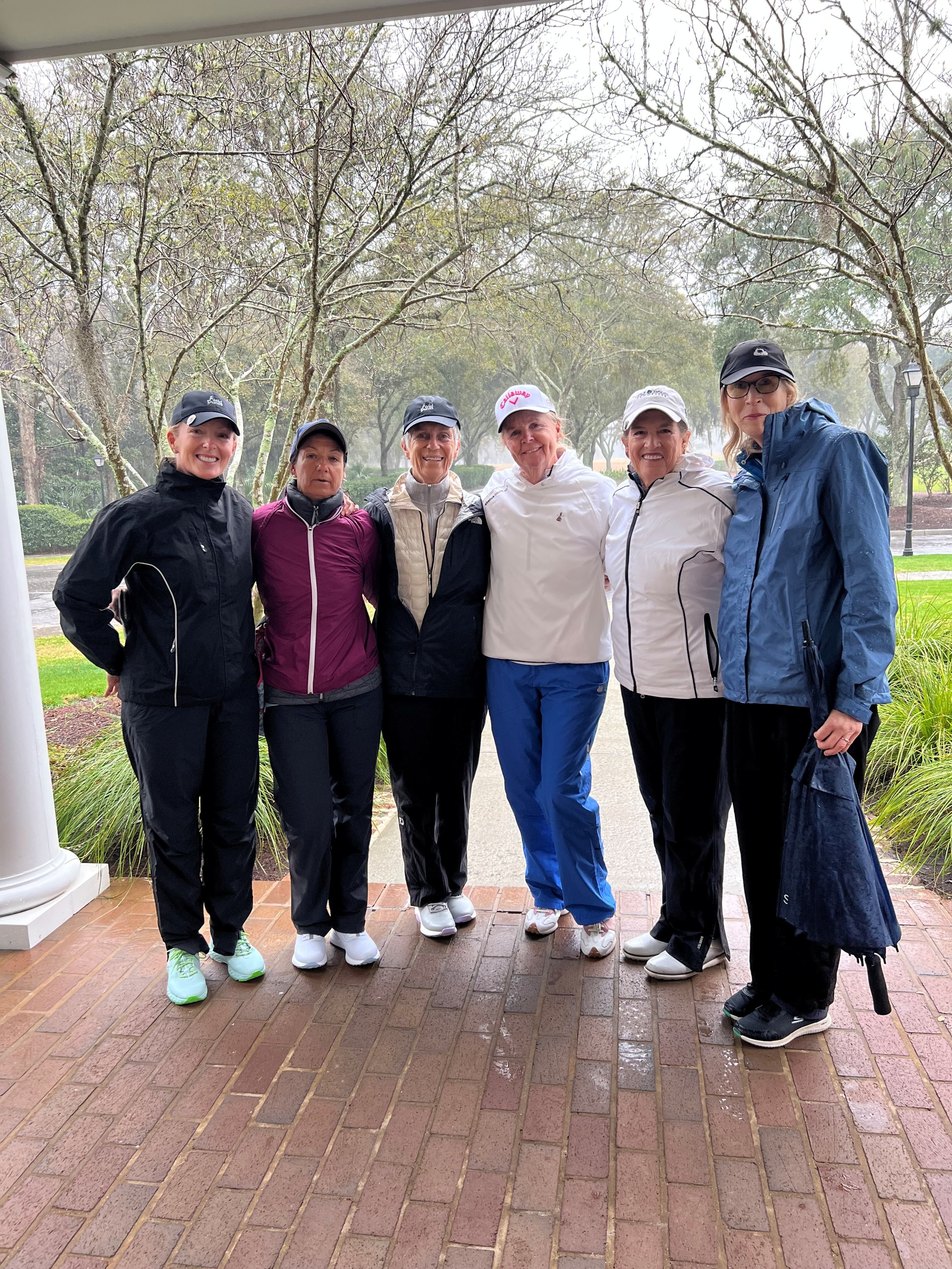 Six Wild Dunes LGA ladies posing together on a rainy day before a round