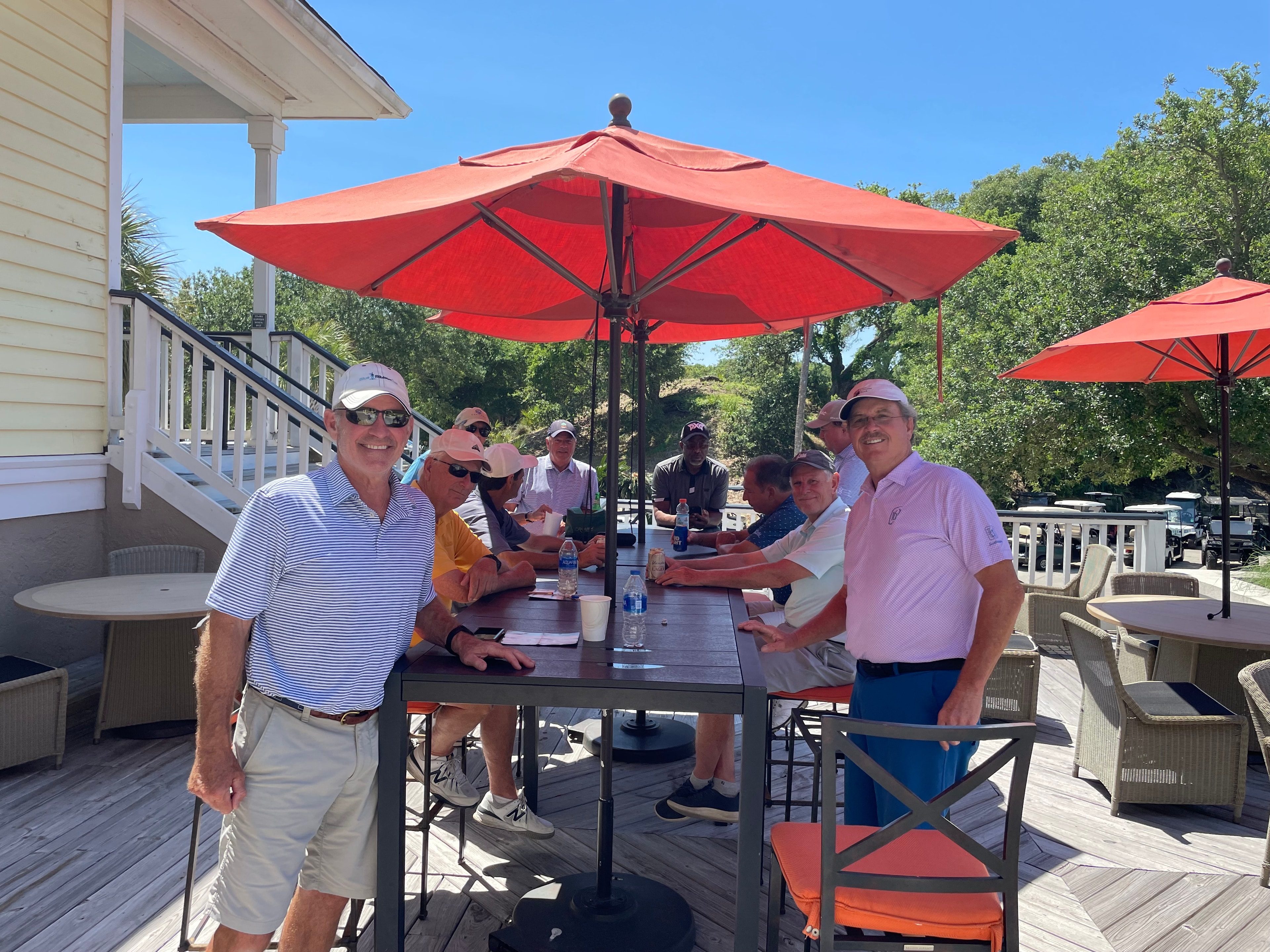 Wild Dunes members relaxing at an outdoor table on the clubhouse deck