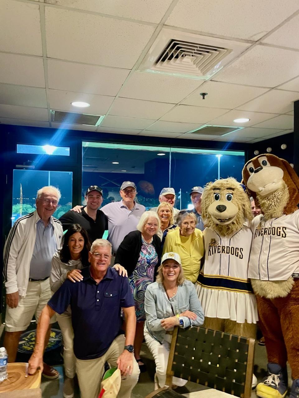 Wild Dunes members posing with the Charleston RiverDogs mascots at a game