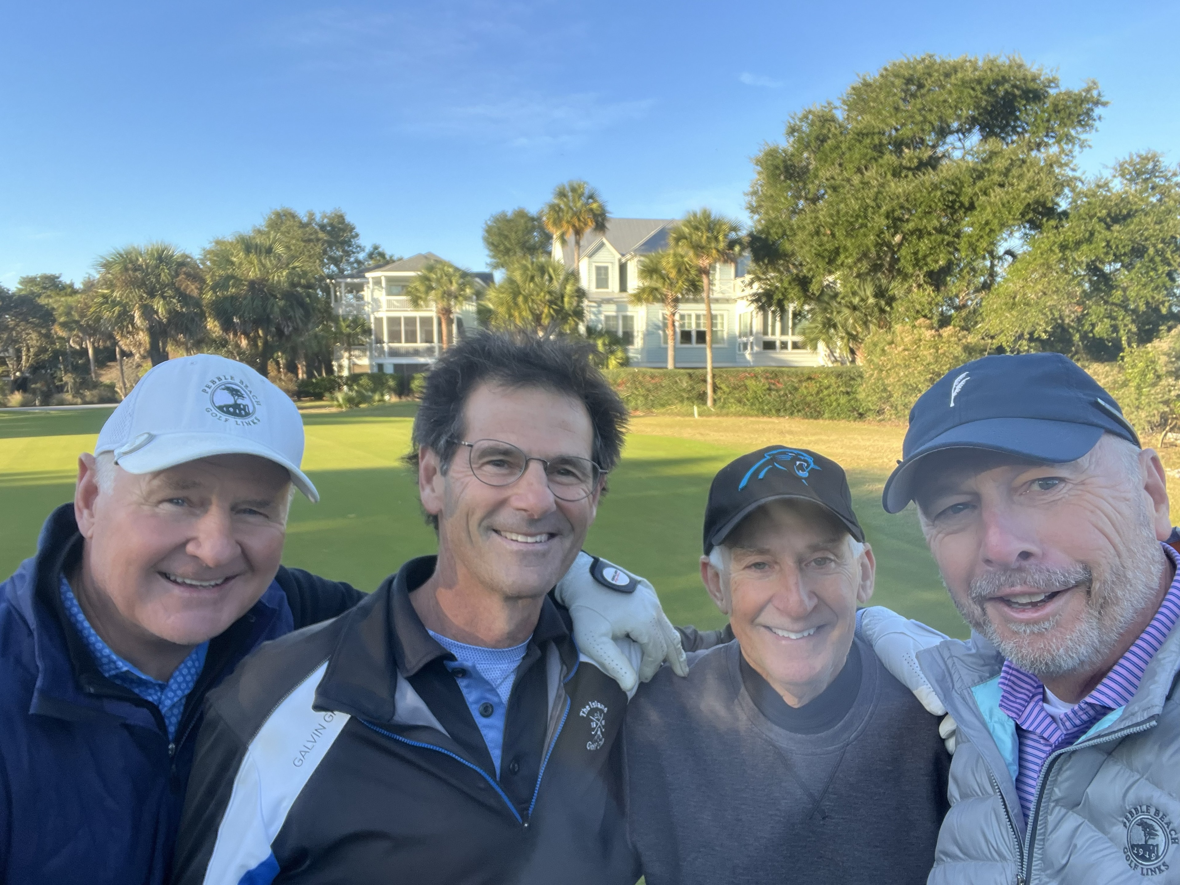 Four Wild Dunes members posing on the course with homes in the background